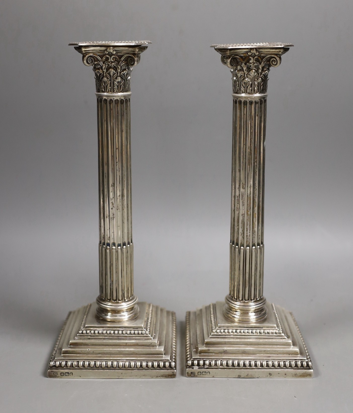 A pair of Edwardian silver Corinthian column candlesticks, Hawksworth, Eyre & Co, Sheffield, 1903, height 25.5cm, weighted.